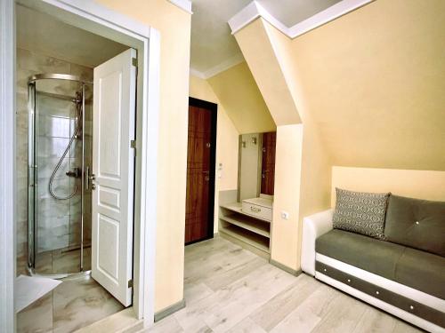 een badkamer met een douche en een bank in een kamer bij Sea View Apartment free parking in Primorsko
