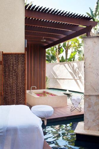 a bedroom with a tub and a swimming pool at Grace Bay Club in Grace Bay