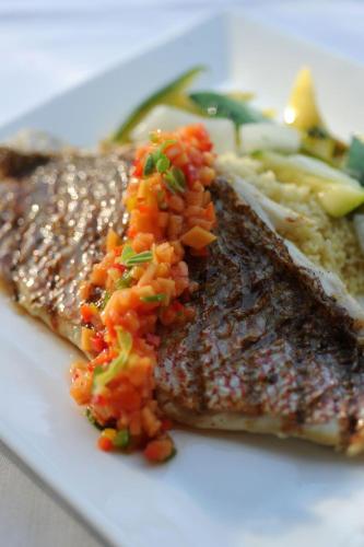 a plate of food with fish and rice and vegetables at Grace Bay Club in Grace Bay