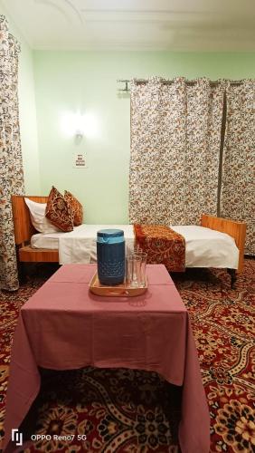 a room with two beds and a table with a table sidx sidx at Moonshine Homestay Kashmir in Srinagar