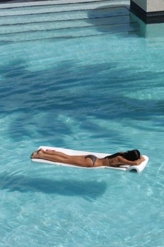 a woman laying on a paddle board in a swimming pool at Grace Bay Club in Grace Bay