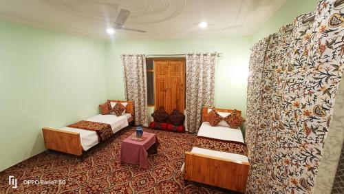 a room with two beds and a table at Moonshine Homestay Kashmir in Srinagar