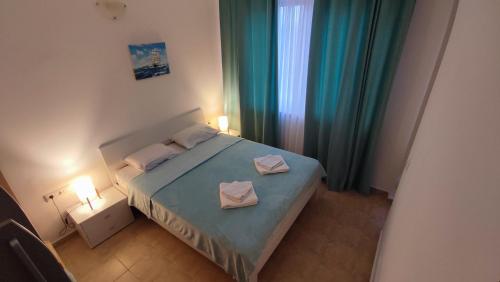 a bedroom with a bed with two towels on it at Cozy apartment with sea view in Pomorie
