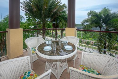 a patio with a table and chairs on a balcony at Pineapple Villa 531 condo in Roatan