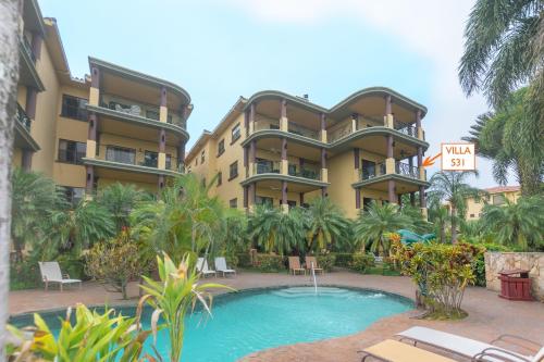 un complejo con piscina frente a un edificio en Pineapple Villa 531 condo, en Roatan