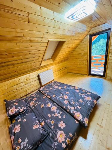 a bedroom with a bed in a wooden cabin at Cabana din Luncă in Bistra