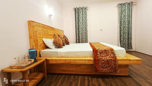 Moonshine Home stay في سريناغار: غرفة نوم بسرير خشبي وطاولة