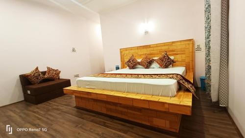 a bedroom with a large bed and a chair at Moonshine Homestay Kashmir in Srinagar