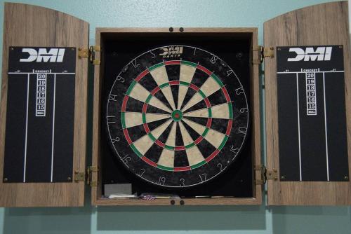 a dartboard in a wooden box with two darts at Spacious Home near Gulf Shores & Orange Beach in Foley