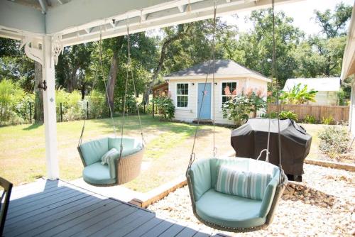 a porch swing with two chairs and a house at Spacious Home near Gulf Shores & Orange Beach in Foley