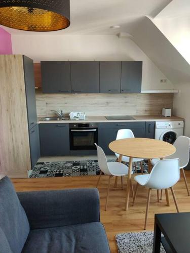 - une cuisine avec une table, une table et des chaises dans l'établissement Appartement centre-ville., à Crozon