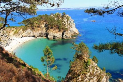 une petite île en océan avec une plage de sable dans l'établissement Appartement centre-ville., à Crozon