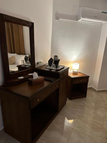 bagno con tavolo da trucco, specchio e lampada di Marvel Hostel a Wadi Musa