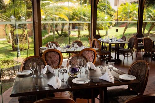 a dining room with tables and chairs and windows at AVANTI HOTEL & CONVENTION CENTER in Cochabamba