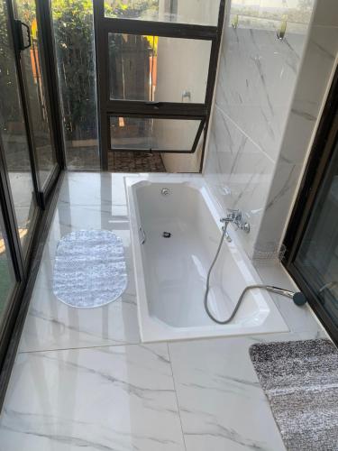 a white bath tub in a bathroom with a window at JB Countrylife Accommodation in Centurion