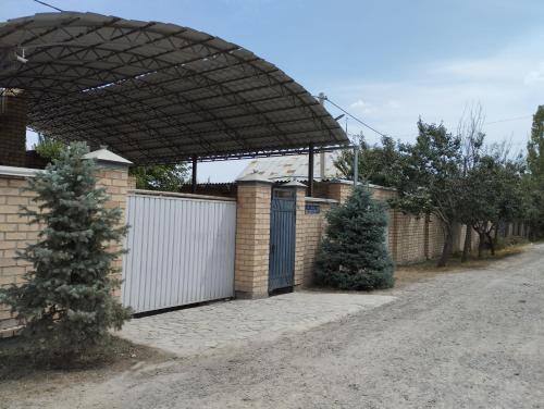 ein Gebäude mit einem Tor und einem Zaun mit einem Zaun in der Unterkunft Гостевой дом Энесай in Bischkek
