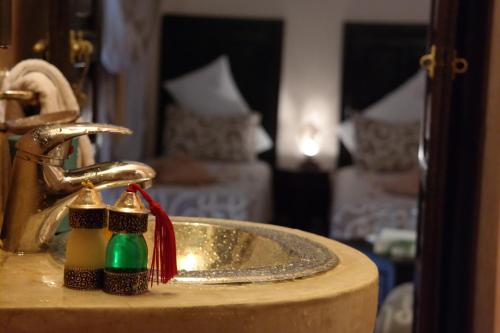 un lavabo con dos dispensadores de jabón. en Riad Hôtel Marraplace en Marrakech