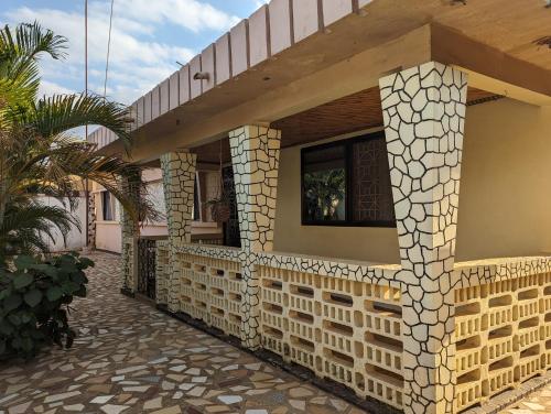 una fachada de una casa con una pared de piedra en The Lion King Homestay en Moshi