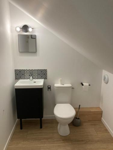 a bathroom with a white toilet and a sink at Rive droite bord de plage in Réville