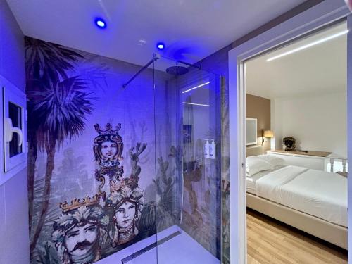 ナポリにあるTorre dell'incantesimoの壁に絵画が描かれたシャワー付きの客室です。