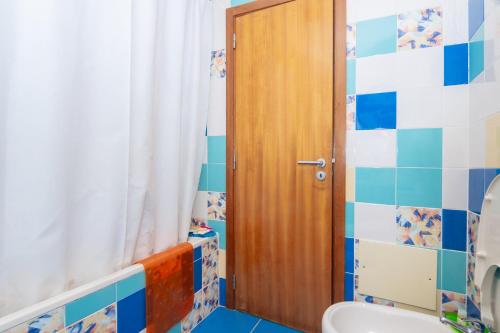 a bathroom with a toilet and a wooden door at Apartamentos Orada - Marina De Albufeira in Albufeira