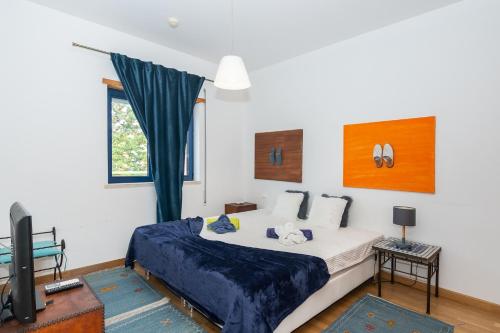 1 dormitorio con 1 cama grande y TV en Apartamentos Orada - Marina De Albufeira, en Albufeira