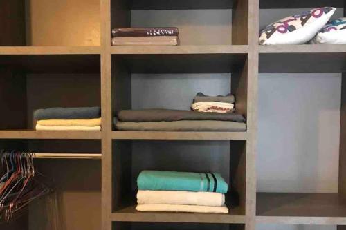 une étagère remplie de serviettes dans une chambre dans l'établissement Proche PARIS/Casino d’Enghien/stade de France/CDG, à Eaubonne