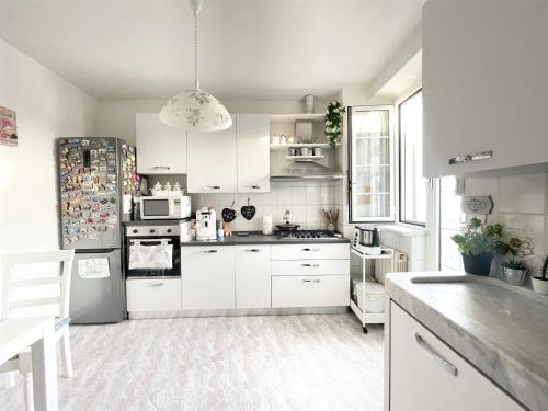 a kitchen with white cabinets and a white appliances at Appartamento Bellavista in Castelnuovo Magra