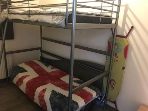 deux lits superposés dans une chambre avec une couverture à motif de drapeau américain dans l'établissement Proche PARIS/Casino d’Enghien/stade de France/CDG, à Eaubonne