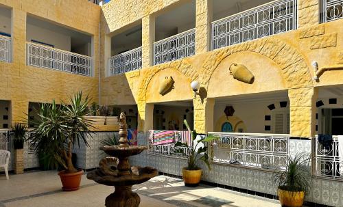 a building with a fountain in the middle of a courtyard at Hotel Paris in Sousse