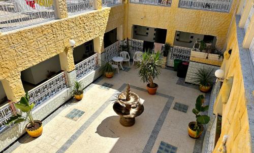 um pátio exterior com uma fonte e vasos de plantas em Hotel Paris em Sousse