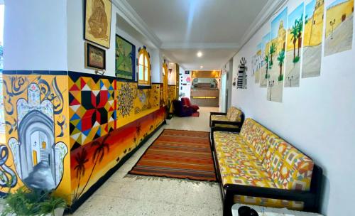 a hallway with a couch and a colorful wall at Hotel Paris in Sousse