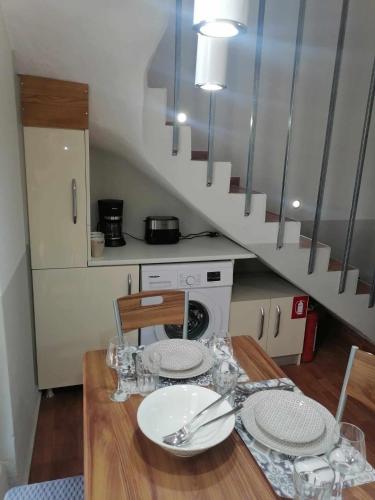 a kitchen with a table with plates and a staircase at Angel's Houses in Skala Kallonis