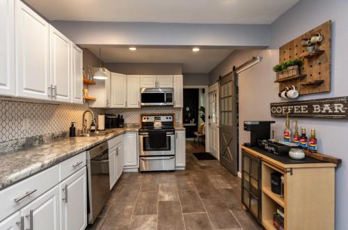 a large kitchen with white cabinets and appliances at Near Drake/Downtown packed w/Amenities - Hot Tub - Movie Theater in Des Moines