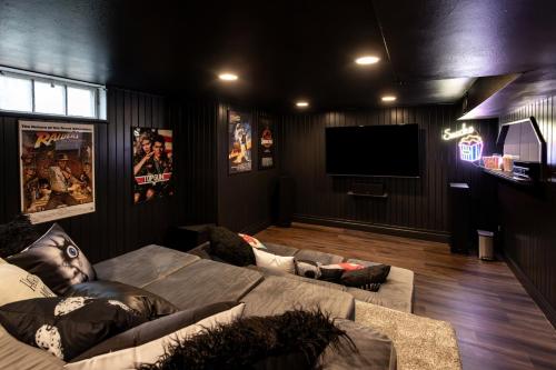 a living room with a couch and a flat screen tv at Near Drake/Downtown packed w/Amenities - Hot Tub - Movie Theater in Des Moines