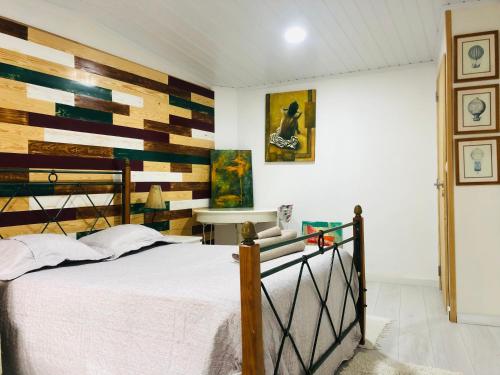Pé do Castelo Casinha في تومار: غرفة نوم مع سرير وبجدار لكنة خشبية