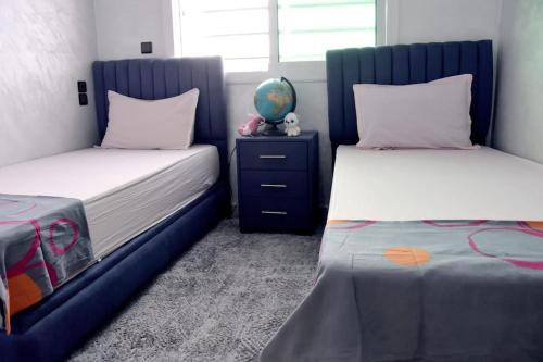 a bedroom with two beds and a blue bed frame at Appartement Azurite - Traditionnel & spacieux in Fès