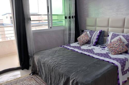 a bedroom with a bed with pillows and a window at Appartement Azurite - Traditionnel & spacieux in Fès