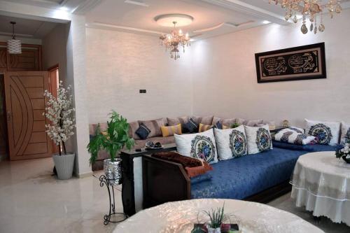 sala de estar con sofá azul y almohadas en Appartement traditionnel marocain & spacieux, en Fez