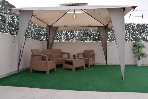a tent with chairs and a table on a green floor at Appartement Azurite - Traditionnel & spacieux in Fès