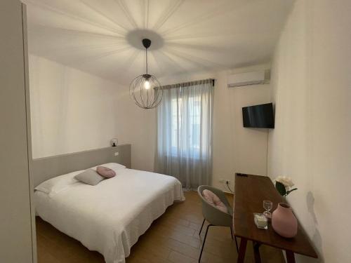 a bedroom with a bed and a table and a chandelier at Casa CarLa in Ancona
