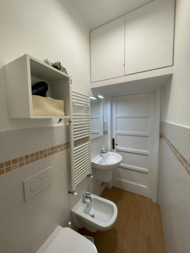 Baño blanco con aseo y lavamanos en Casa CarLa, en Ancona