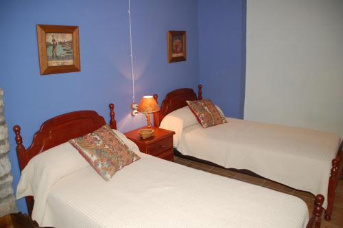 Duas camas num quarto com paredes azuis em Cal Balico Fatarella em Fatarella