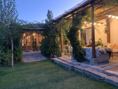 una casa con un patio al aire libre con hiedra. en Hotel Vendimia Parador, en Santa Cruz