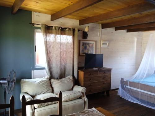 a living room with a couch and a television at Cabañas 5 Brujas in Punta Del Diablo