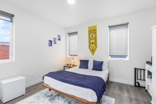 a white bedroom with a bed and two windows at Stag Sweet Suite in Seattle