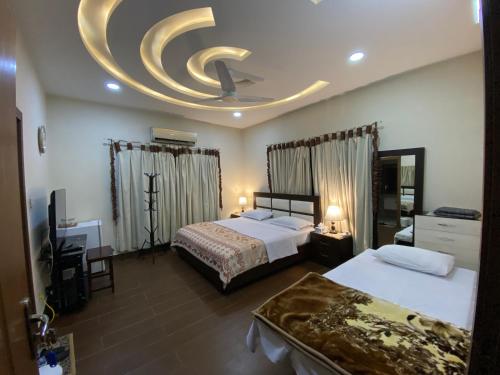 a hotel room with two beds and a circular ceiling at Alpha Guest House in Rawalpindi