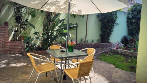 una mesa con sillas y una sombrilla en el patio en Casa céntrica en Salta