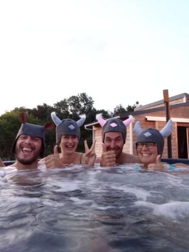 un groupe de trois hommes en costume dans une piscine dans l'établissement Bain Nordique SPA - Tiny house à la campagne, à La Boissière