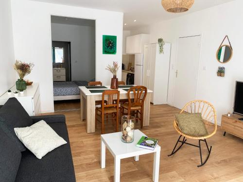 un salon avec un canapé et une table dans l'établissement Appartement centre-ville cosy WIFI et Netflix, à Fontenay-le-Comte